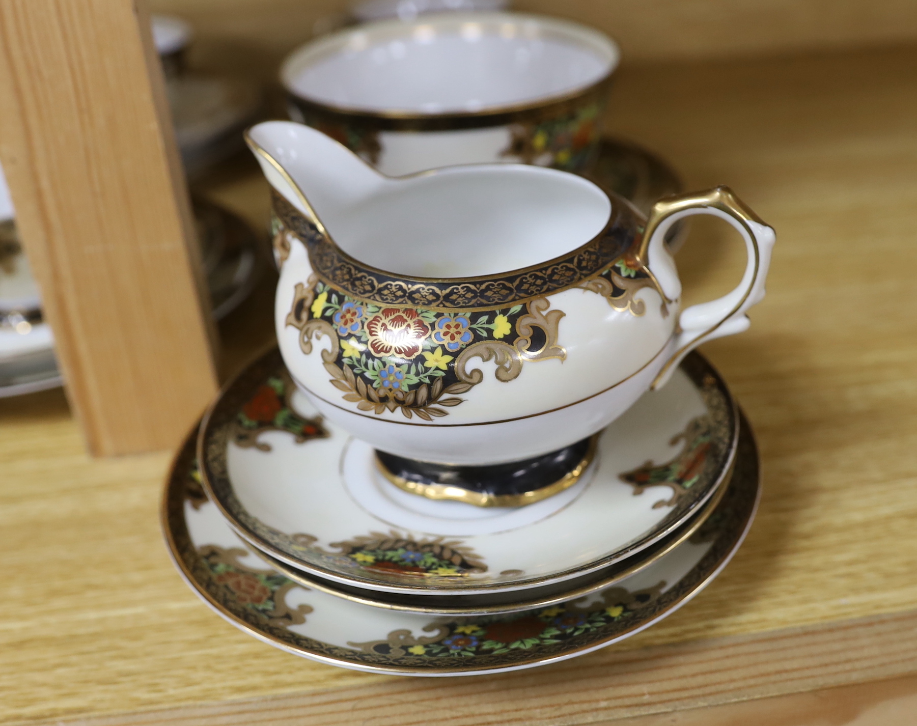A Japanese Noritake floral and gilt tea set, comprising a sugar bowl, a milk jug, nine cups, plus saucers and tea plates